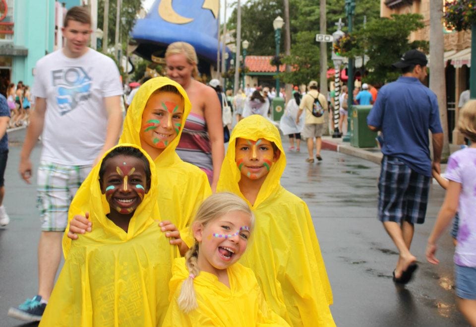 Transracial adoptive family in ponchos at Disneyworld