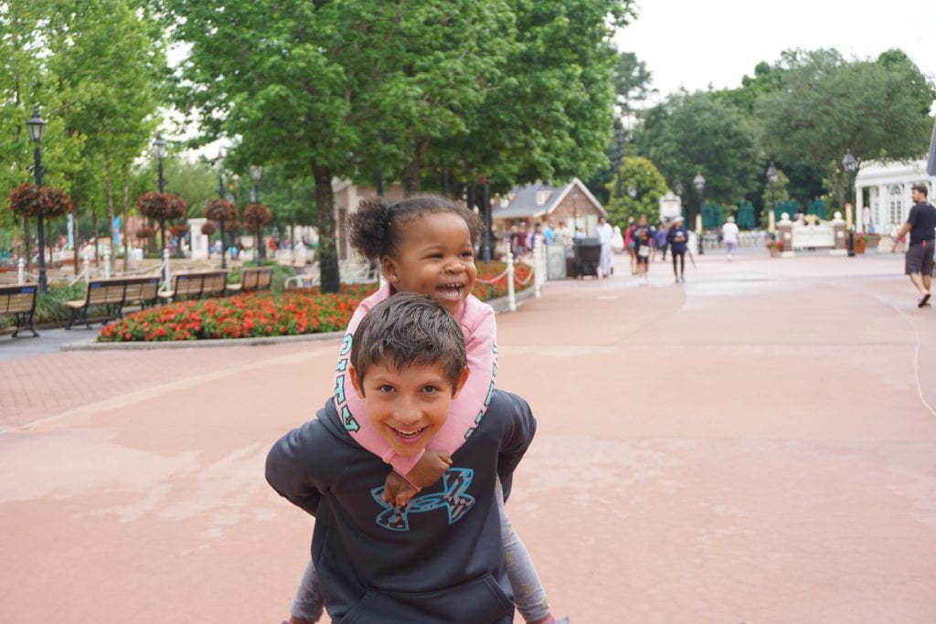 DIsney World Stroller Rental - Transracial adoptive sister gets a piggy back ride from her brother in Epcot during Disney SMMC | Global Munchkins