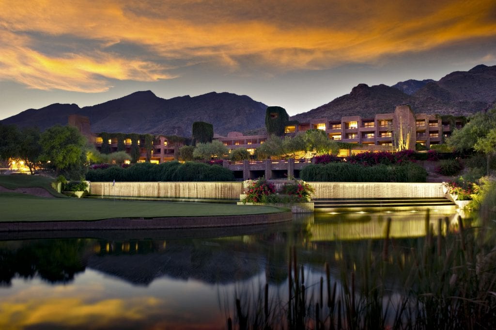 Long exposure of a luxury hotel resort. A golf course and pond is in the foreground and foothill mountians in the background.