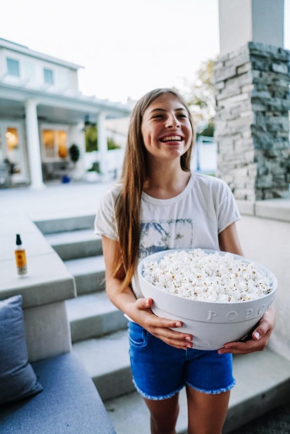 summer bucketlist for teens - teenage girl holding a bowl of popcorn 