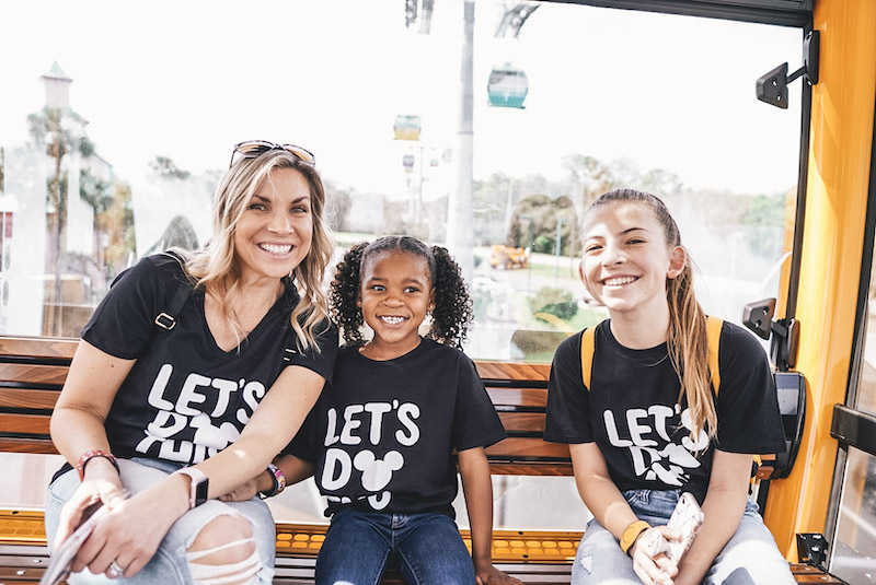 mom and daughters sitting on Disney Skyliner - Disney World transportation guide