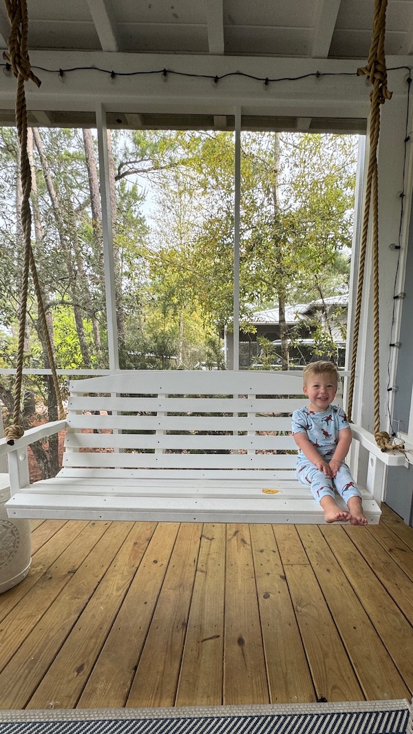 toddler sitting on porch swing